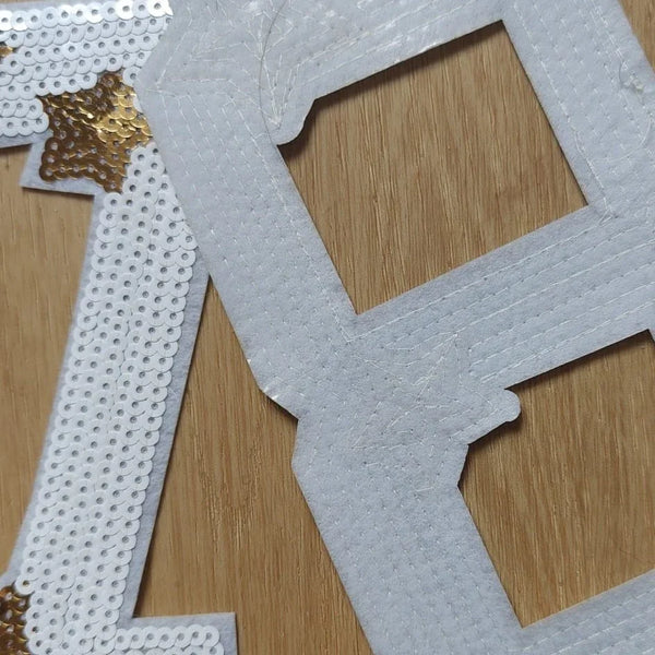Appliqués thermocollants blancs à sequins dorés pour couture sur fond bois ACCESSOIRES LEDUC