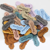 Set of 7 Fake Suede Labels - Peanut Shape - tagged "Handmade with ♥" - size40x15mm (Sew-on) - ACCESSOIRES LEDUC BV